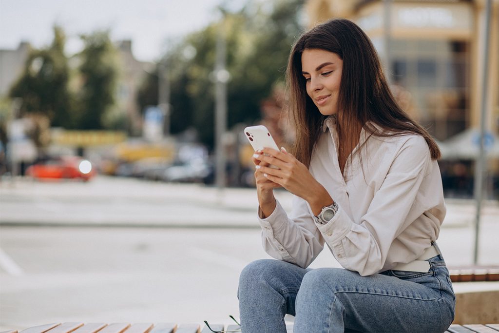 mujer-joven-telefono-fuera-calle